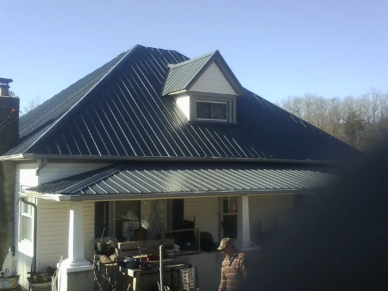 Dark blue standing seam metal roof with a dormer above a front porch in Buckeystown