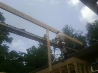 Carpenter setting a ridge beam over a new addition frame — Ice Dam Removal by Roofing Brothers in Buckeystown